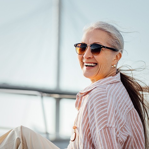 a smiling woman sitting on a sailboat