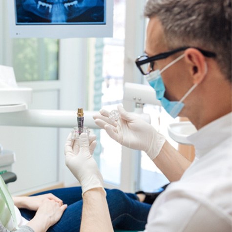 dentist explaining dental implant to patient 