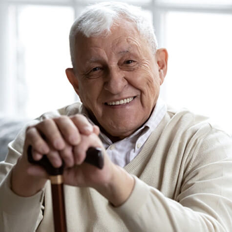 senior man sitting on a couch and smiling