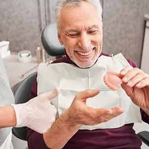 Patient in Houston smiling at his new dentures