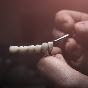 Lab technician painting teeth