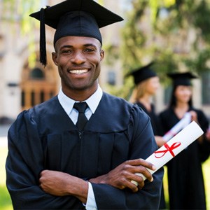 Man smiling in cap and gown