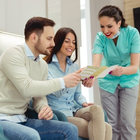 Dental team member and patient reviewing dental insurance policy