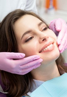 young woman smiling while visiting cosmetic dentist 