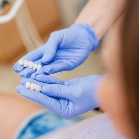 Dentist showing patient dental bridges