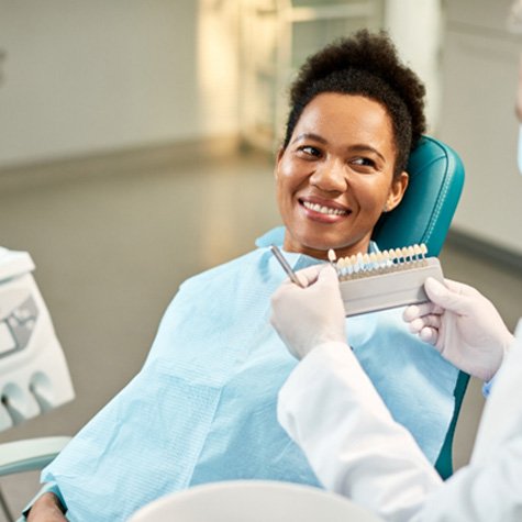 Smiling woman in dental chair getting veneers