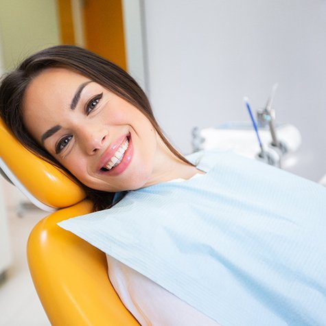 Young woman smiling while waiting in dental chair