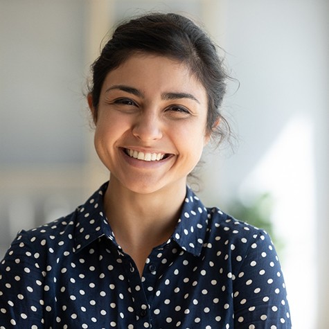 Woman with spotted shirt smiling at home