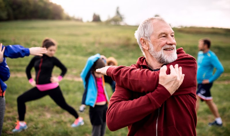 An older man doing exercise with a group