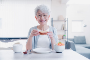 Senior woman enjoying a meal at her table and smiling 